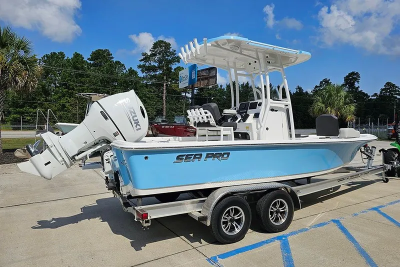 Slide: The Image of 2026 Sea Pro 230 Bay boat on trailer, featuring Suzuki outboard motor, parked outdoors. - 6