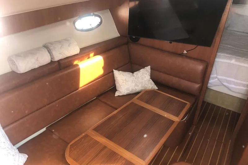 Slide: The Image of 1998 Tiara Yachts 3700 Open interior with leather seating, wooden table, and mounted TV. - 12