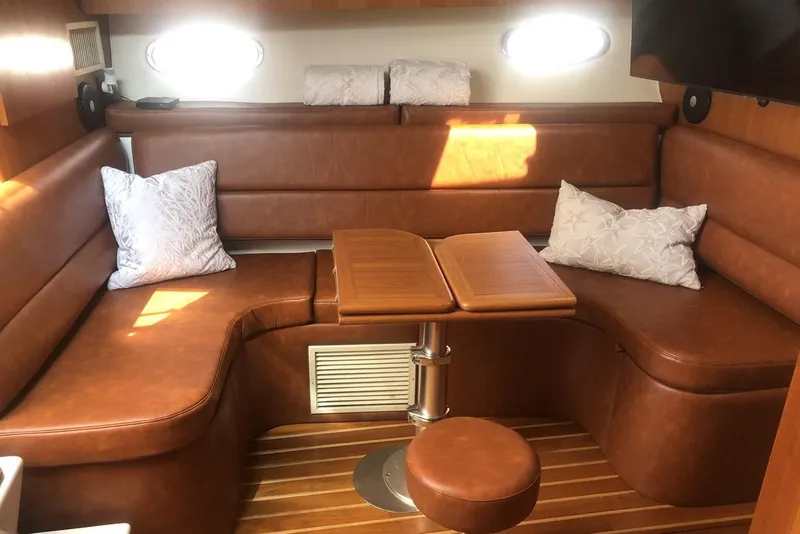 Slide: The Image of 1998 Tiara Yachts 3700 Open interior with brown leather seating and wooden table. - 15