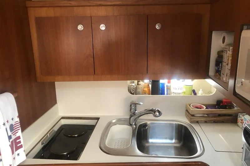 Slide: The Image of Compact yacht kitchen with wooden cabinets, sink, and stove in a 1998 Tiara Yachts 3700 Open. - 16