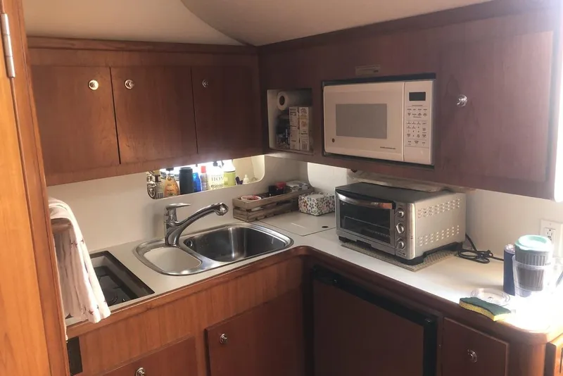 Slide: The Image of Compact kitchen in 1998 Tiara Yachts 3700 Open, featuring microwave, sink, and toaster oven. - 17