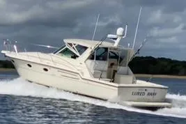 Slide: The Image of 1998 Tiara Yachts 3700 Open cruising on water under cloudy skies. - 2