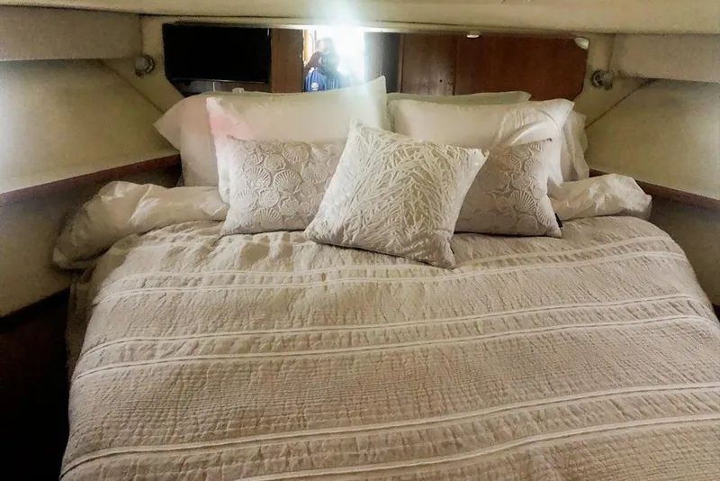 Slide: The Image of Cozy cabin bedroom in 1998 Tiara Yachts 3700 Open, featuring elegant bedding and pillows. - 20