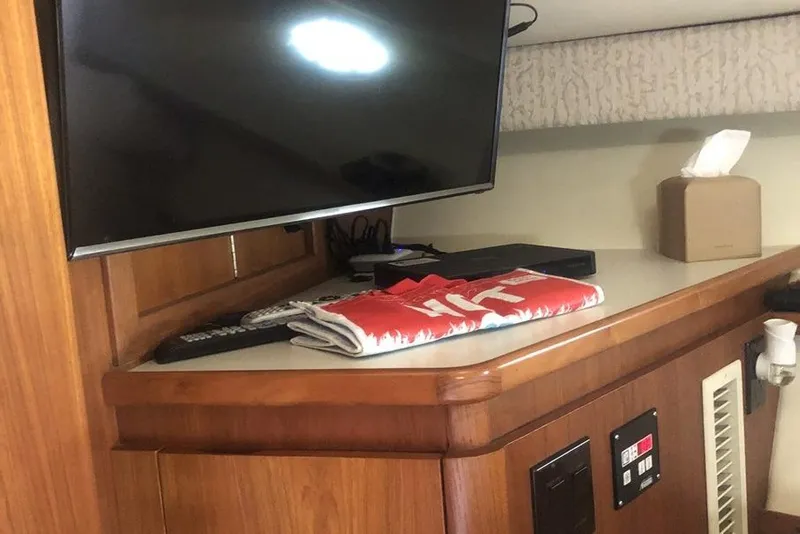 Slide: The Image of 1998 Tiara Yachts 3700 Open interior with TV, remote, and tissue box on wooden counter. - 23