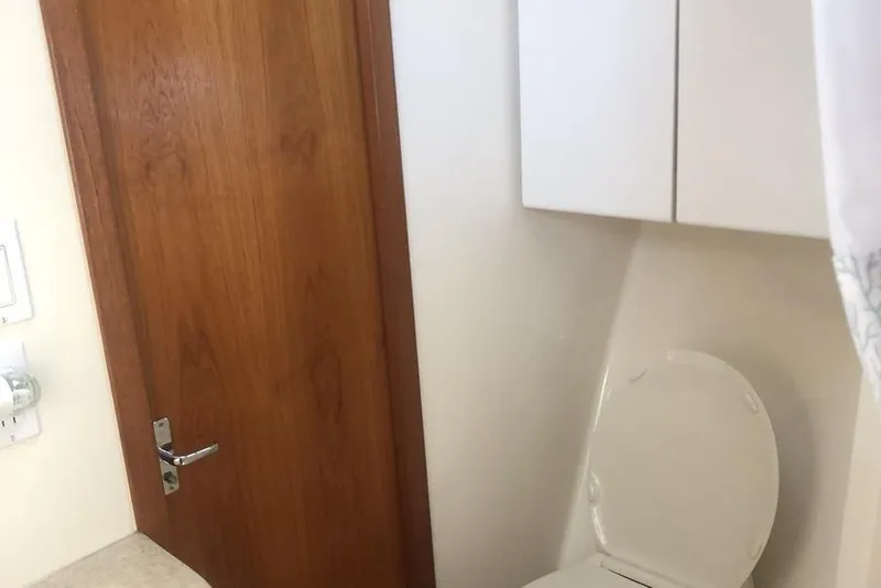 Slide: The Image of Bathroom interior of 1998 Tiara Yachts 3700 Open, featuring wooden door and toilet. - 26