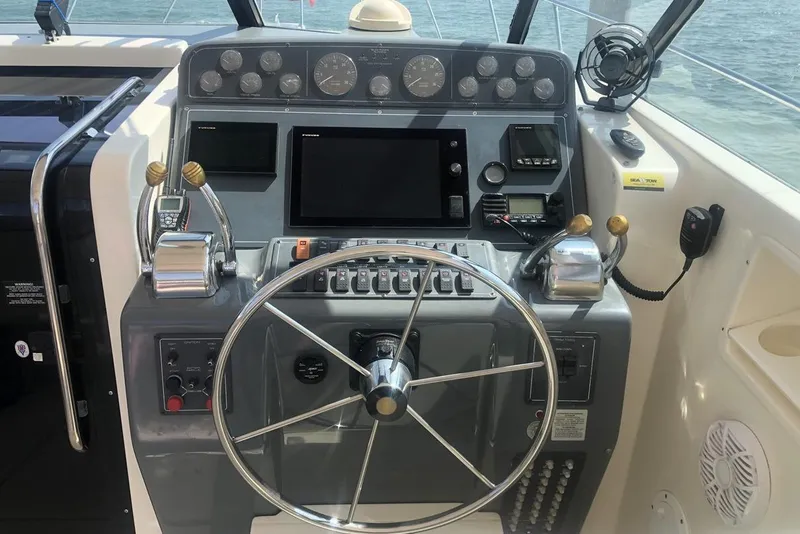 Slide: The Image of 1998 Tiara Yachts 3700 Open helm with steering wheel and control panel. - 5