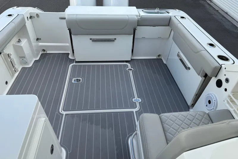 Slide: The Image of 2024 Pursuit DC 266 Dual Console boat interior with gray flooring and cushioned seating. - 19