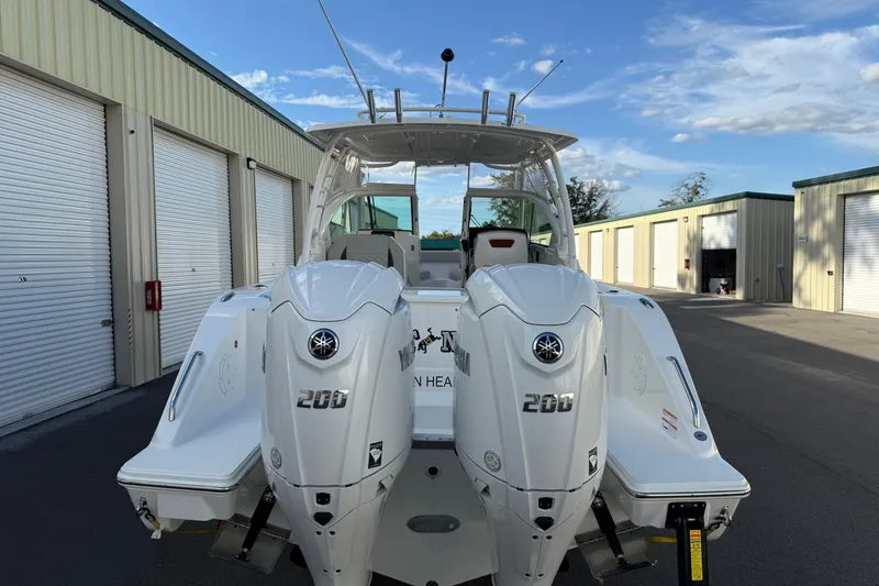 Slide: The Image of 2024 Pursuit DC 266 Dual Console boat with twin Yamaha 200 engines, parked outdoors. - 25