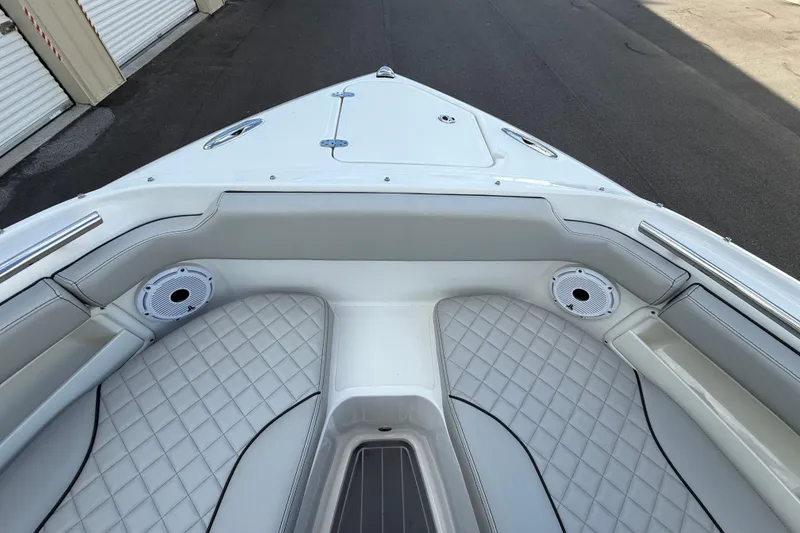 Slide: The Image of 2024 Pursuit DC 266 Dual Console boat interior with cushioned seating and speakers. - 31