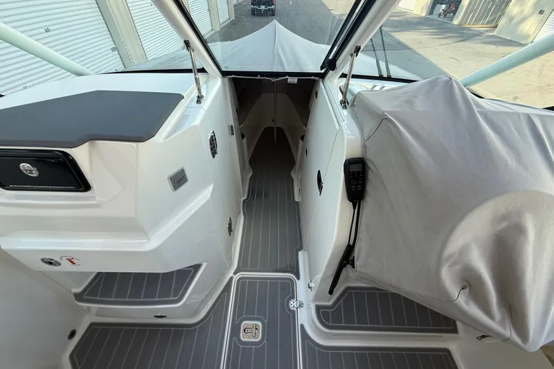 Slide: The Image of 2024 Pursuit DC 266 Dual Console boat interior with covered controls and sleek design. - 34