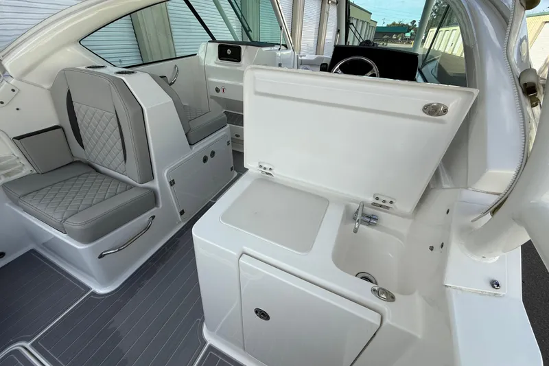 Slide: The Image of 2024 Pursuit DC 266 Dual Console interior with seating and sink area. - 36