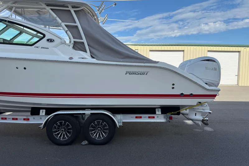 Slide: The Image of 2024 Pursuit DC 266 Dual Console boat on trailer, side view. - 37