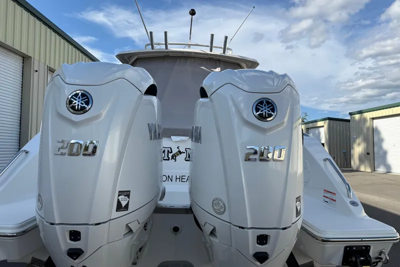 Slide: The Image of 2024 Pursuit DC 266 Dual Console with twin Yamaha 200 engines, docked outdoors. - 4