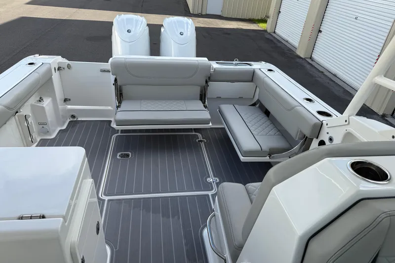 Slide: The Image of 2024 Pursuit DC 266 Dual Console boat interior with gray seating and twin engines. - 40