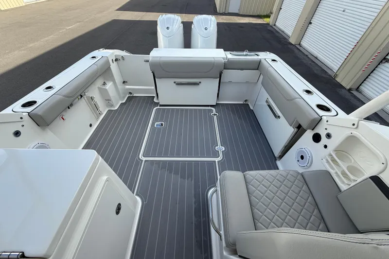 Slide: The Image of 2024 Pursuit DC 266 Dual Console boat interior with gray seating and deck. - 41