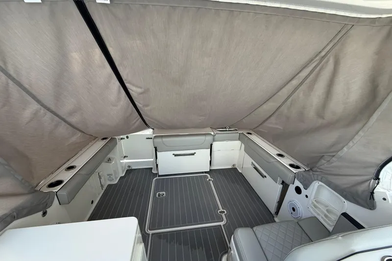 Slide: The Image of 2024 Pursuit DC 266 Dual Console interior with gray seating and covered deck area. - 42