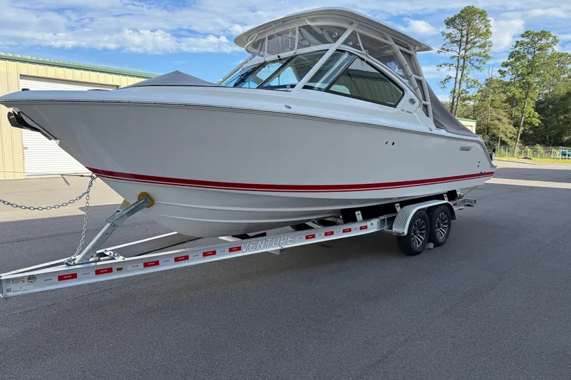Slide: The Image of 2024 Pursuit DC 266 Dual Console boat on trailer, parked outdoors. - 45