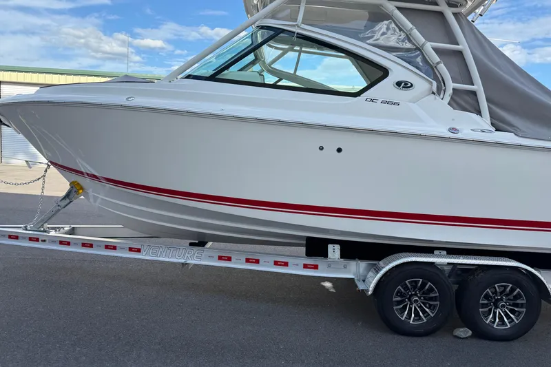 Slide: The Image of 2024 Pursuit DC 266 Dual Console boat on trailer, side view. - 46