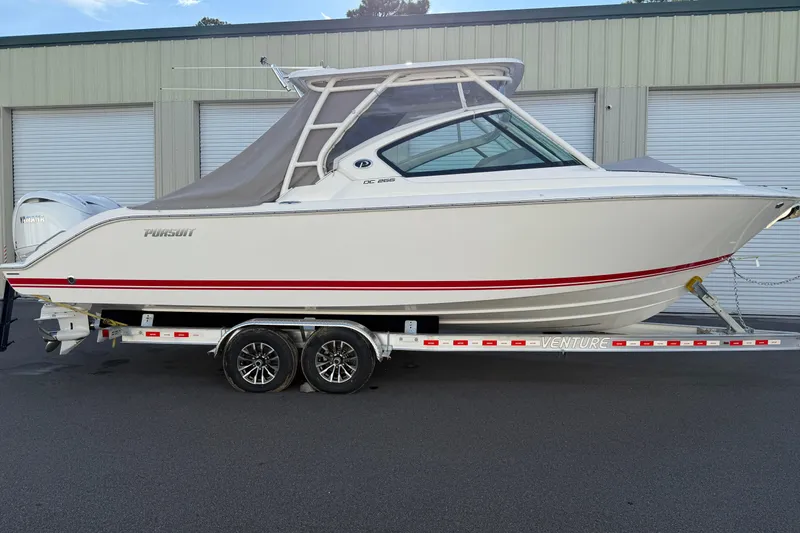 Slide: The Image of 2024 Pursuit DC 266 Dual Console boat on trailer, side view. - 51