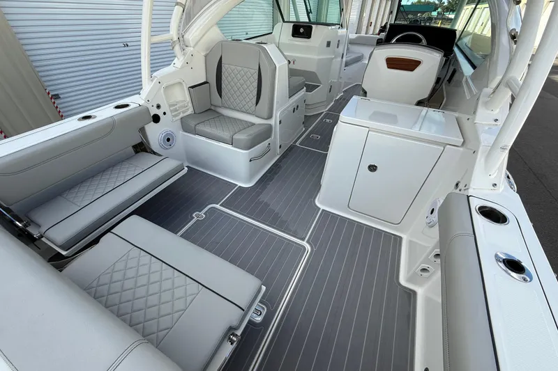 Slide: The Image of 2024 Pursuit DC 266 Dual Console boat interior with gray seating and sleek design. - 6