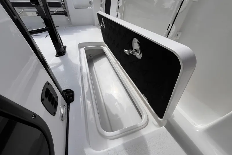 Slide: The Image of 2026 Tidewater 256 CC Adventure boat interior with open storage compartment. - 16
