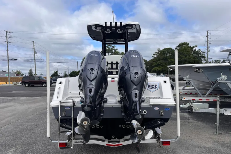 Slide: The Image of 2026 Tidewater 256 CC Adventure boat with dual outboard engines, parked on a trailer. - 3