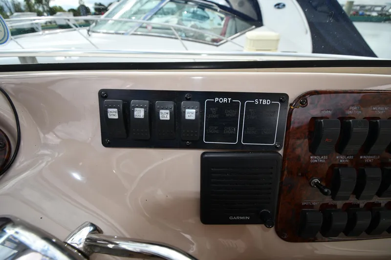 Slide: The Image of Control panel of a 2003 Sea Ray 460 Sundancer yacht with switches and Garmin device. - 16