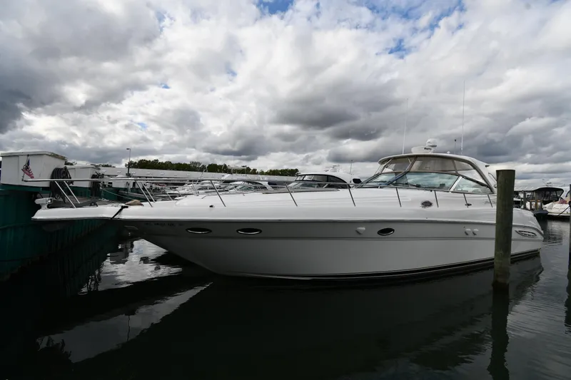 Slide: The Image of 2003 Sea Ray 460 Sundancer yacht docked under cloudy skies. - 2