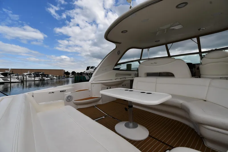 Slide: The Image of 2003 Sea Ray 460 Sundancer yacht with spacious seating and table, docked under a blue sky. - 21