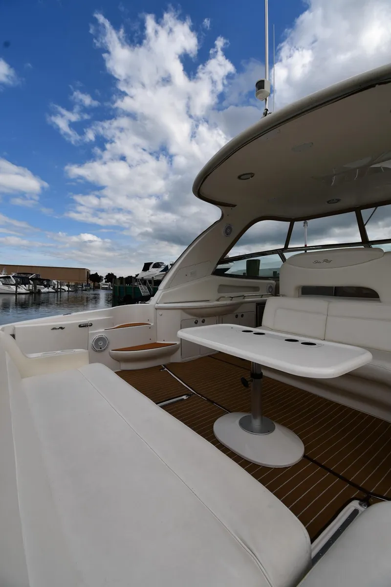 Slide: The Image of 2003 Sea Ray 460 Sundancer yacht with spacious deck and seating under a blue sky. - 22
