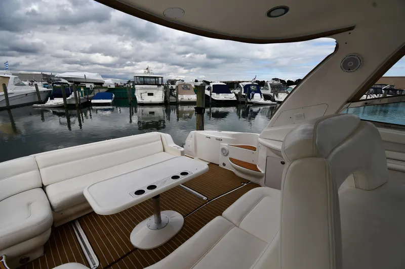 Slide: The Image of 2003 Sea Ray 460 Sundancer yacht interior with marina view, featuring white seating and table. - 25