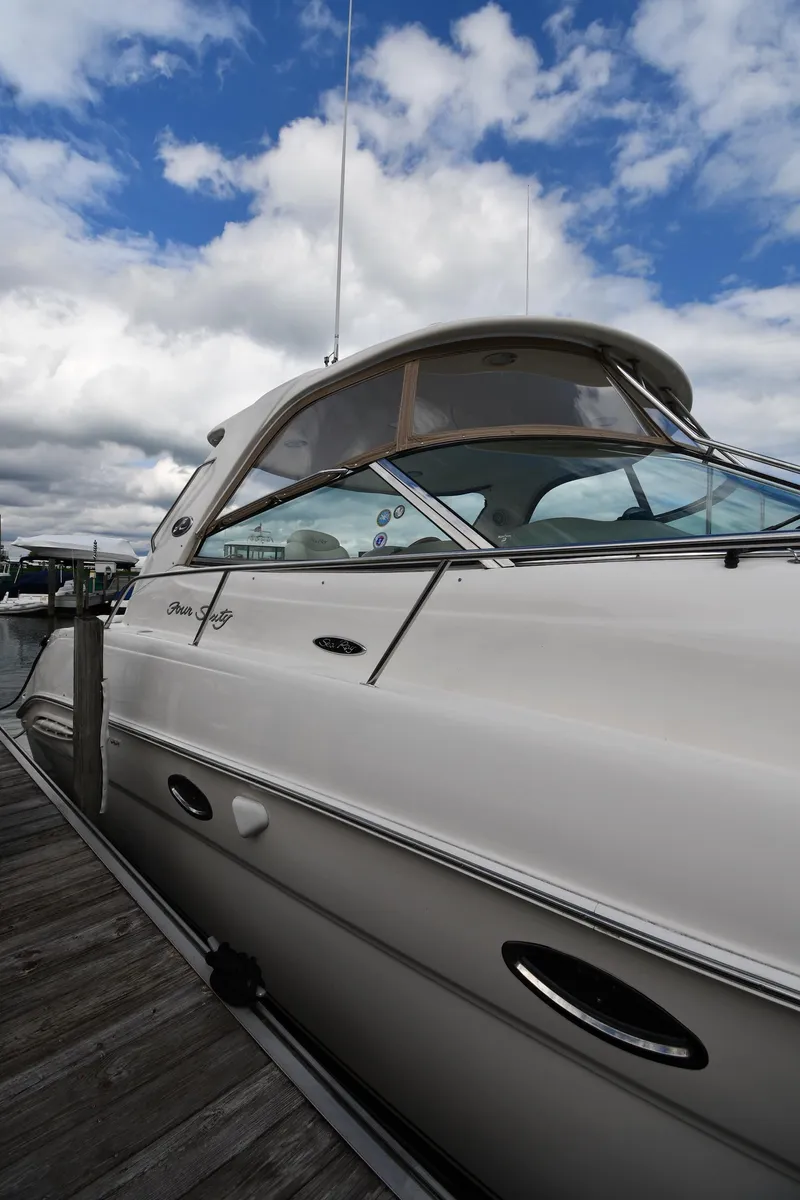 Slide: The Image of 2003 Sea Ray 460 Sundancer yacht docked under a partly cloudy sky. - 3