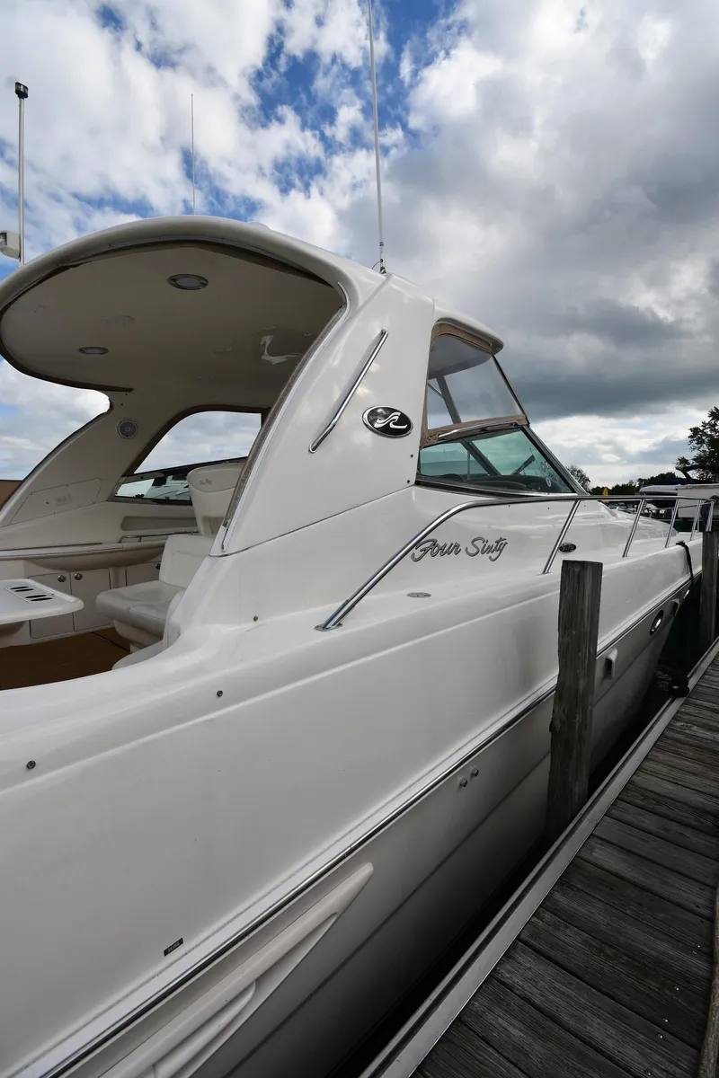 Slide: The Image of 2003 Sea Ray 460 Sundancer yacht docked under cloudy skies. - 4