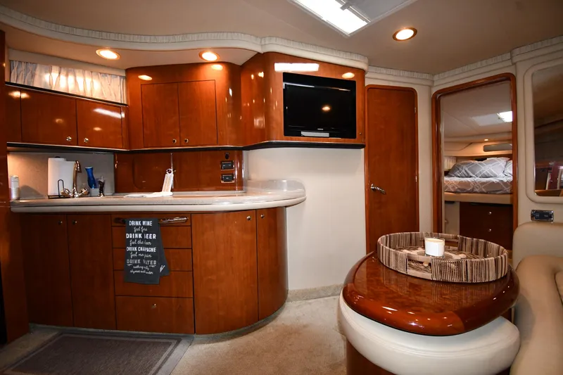 Slide: The Image of 2003 Sea Ray 460 Sundancer interior with kitchen, TV, and seating area. - 46