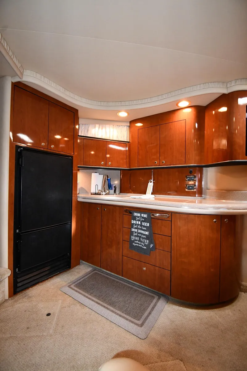Slide: The Image of Interior of 2003 Sea Ray 460 Sundancer yacht with wooden cabinetry and modern kitchen amenities. - 49