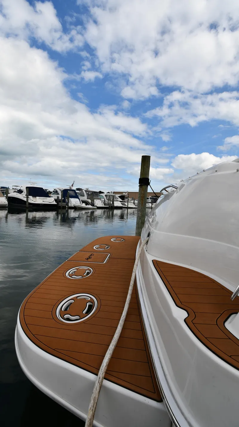 Slide: The Image of 2003 Sea Ray 460 Sundancer yacht docked at marina under cloudy sky. - 5
