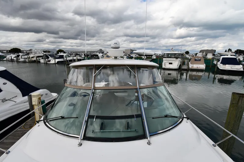 Slide: The Image of 2003 Sea Ray 460 Sundancer yacht docked in a marina under cloudy skies. - 9