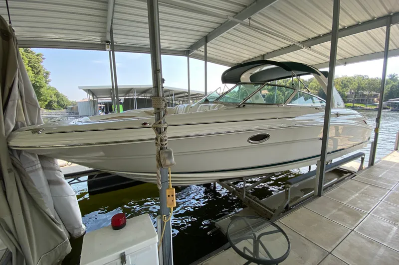 Slide: The Image of 2002 Sea Ray 290 SLX boat docked under a covered marina. - 1