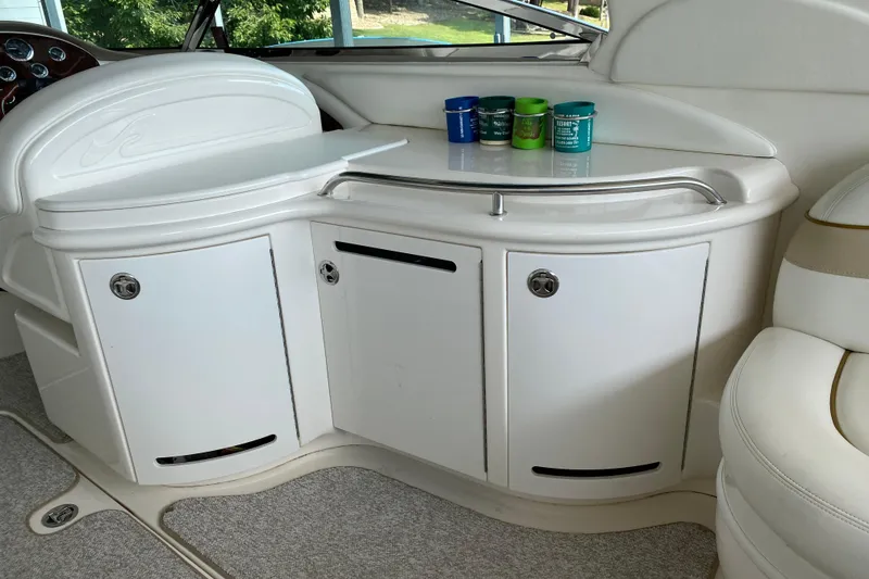 Slide: The Image of Interior of 2002 Sea Ray 290 SLX boat with white cabinetry and colorful cups. - 10