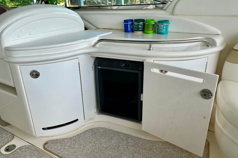 Slide: The Image of 2002 Sea Ray 290 SLX boat interior with open cabinet and small refrigerator. - 11
