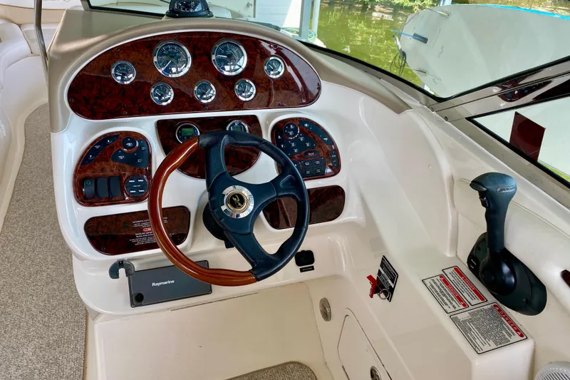 Slide: The Image of 2002 Sea Ray 290 SLX boat dashboard with wood accents and steering wheel. - 12