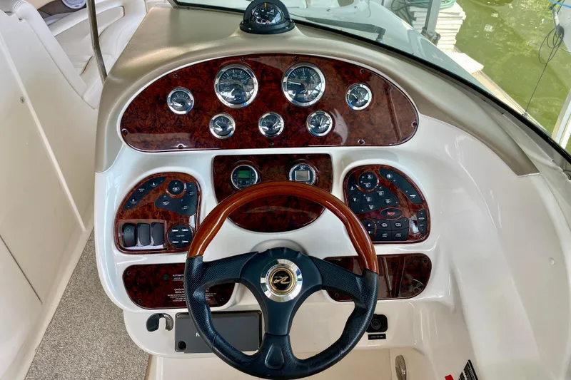 Slide: The Image of 2002 Sea Ray 290 SLX boat dashboard with wood accents and steering wheel. - 13