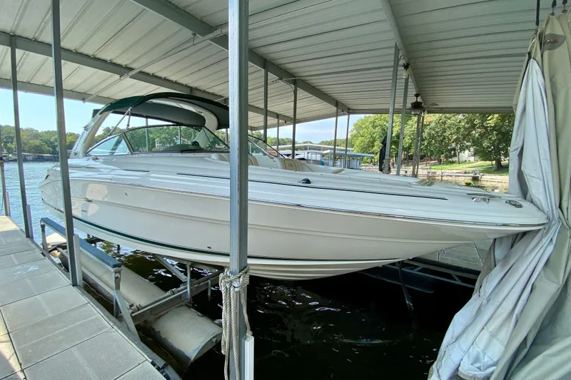 Slide: The Image of 2002 Sea Ray 290 SLX boat docked under a covered marina. - 2