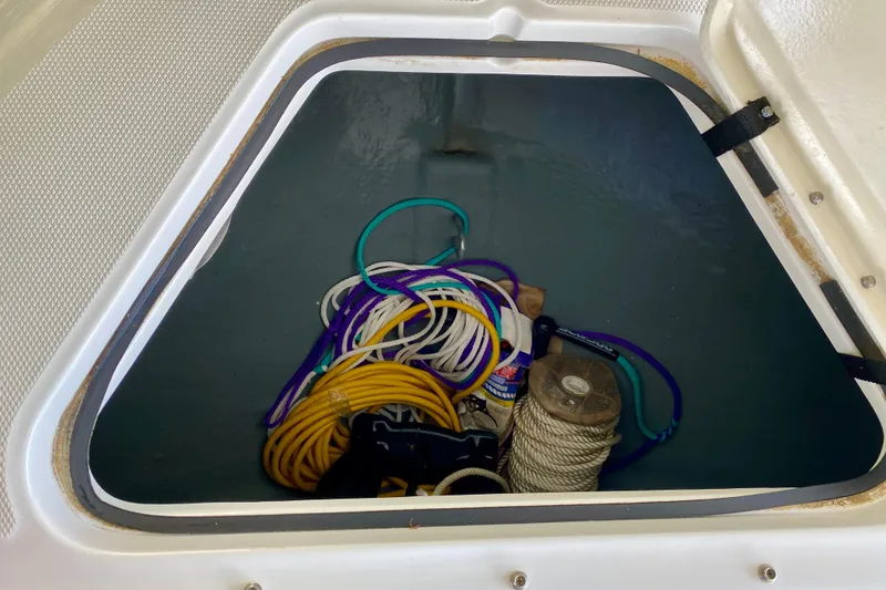Slide: The Image of Storage compartment of a 2002 Sea Ray 290 SLX boat with ropes and supplies. - 21