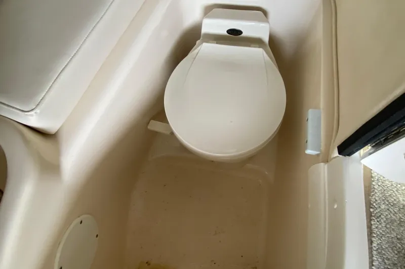 Slide: The Image of Interior of 2002 Sea Ray 290 SLX boat featuring a compact marine toilet. - 25