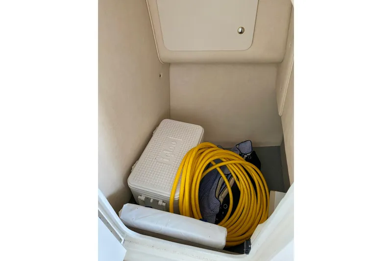 Slide: The Image of Storage compartment in 2002 Sea Ray 290 SLX with cooler and yellow hose. - 26