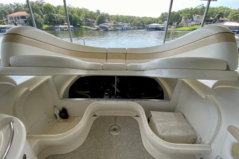Slide: The Image of 2002 Sea Ray 290 SLX boat interior with seating and engine compartment, overlooking a scenic lake. - 28
