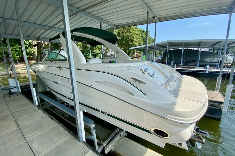Slide: The Image of 2002 Sea Ray 290 SLX boat docked under covered marina, side view. - 3