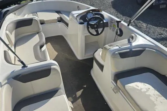 Slide: The Image of 2019 Bayliner Element E18 boat interior with spacious seating and steering console. - 2