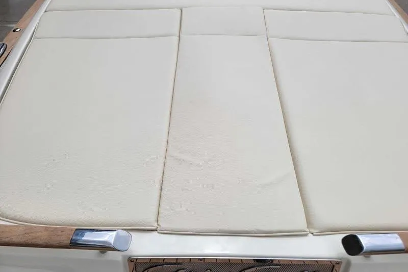 Slide: The Image of 2024 Chris-Craft Launch 27 boat with beige cushioned seating and wooden accents. - 10